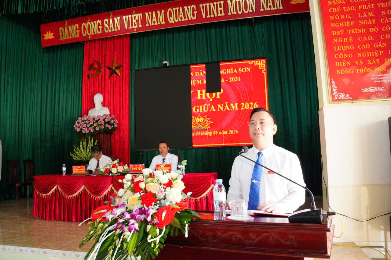 A person in a suit and tie at a podium Description automatically generated